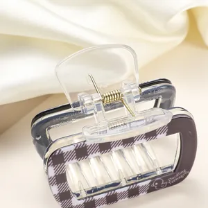 Macro view of purple checkered acrylic hair claw clip with golden metal spring details