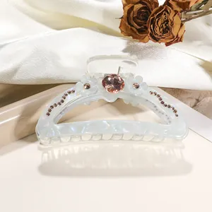 Detail of 9cm iridescent hair claw clip with white flower and pink rhinestone accents