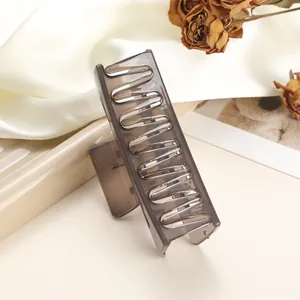 Detailed close-up of large rectangular smoky grey hair claw clip on soft white satin
