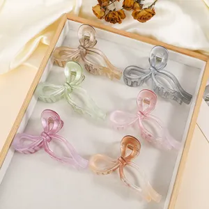 Macro detail of six butterfly-shaped hair claws in various translucent resin colors