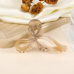 Detailed view of amber acetate butterfly hair claw clip on soft beige silk background