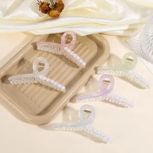 Detail von bonbonfarbenen Organza-Haarklammern mit Perlenakzenten im Tablett