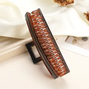 Macro shot of large translucent amber rectangular hair claw clip for thick hair styling