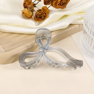 Detailed view of a grey translucent butterfly hair claw clip with metal spring mechanism