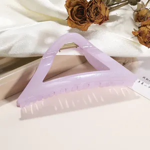 Detailed view of large lavender glitter hair claw clip with metallic spring on white silk