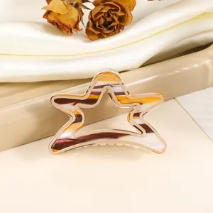Star shaped hollow hair claw with orange and brown marble texture on satin background
