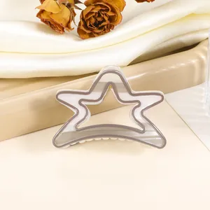 Close-up of a double-layered hollow star hair claw with elegant cream and grey finish