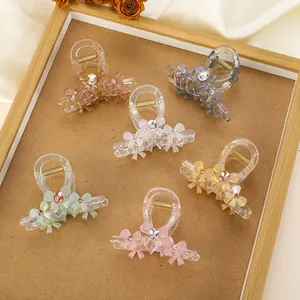 Close-up of bow hair clips with faux gemstone accents in six pastel colors on display