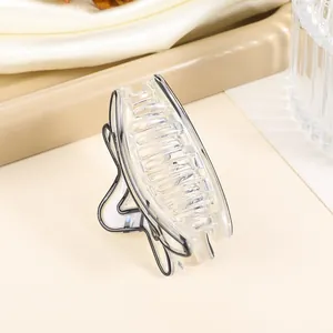 Detail of transparent star hair claw clip with black outlines on beige background