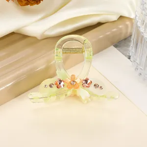 Details einer hellgrünen Blumen-Haarklammer mit glänzenden Strasssteinen und Acryl