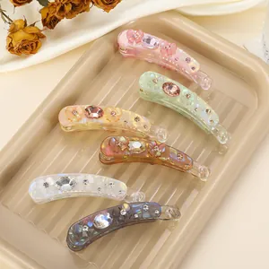 Detailed set of 6 iridescent banana clips with butterfly design on a beige tray
