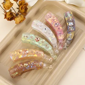 Détail de pinces banane de 8,5cm avec fleurs en strass déclinées en six couleurs pastel douces