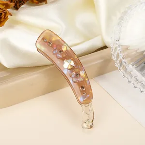 Détail du clip banane en résine ambrée avec strass étincelants et accents floraux