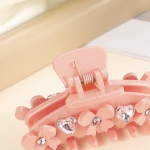 Pink bow hair claw clip with heart rhinestones and floral details for summer hairstyles