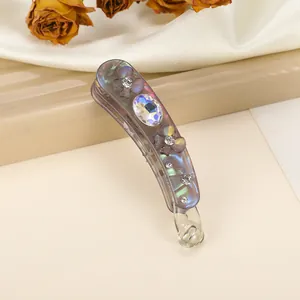 Macro detail of iridescent purple banana clip with floral rhinestones and crystal accents