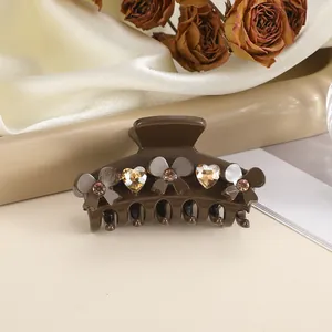 Close-up of brown bow hair claw clip with champagne heart rhinestones on satin