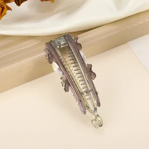 Detail of banana clip with rhinestones and floral accents on beige silk fabric