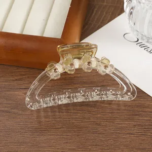 Dettaglio di pinza per capelli con fiori gialli e strass su un vassoio di legno