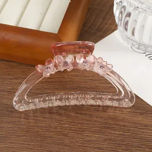 Detail van roze transparante vlinderhaarklem met strass steentjes op houten achtergrond