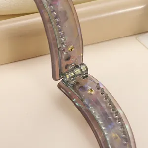 Pince banane papillon 8,5cm violette translucide avec détails strass et dents internes