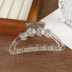 Dettaglio della molletta per capelli trasparente con fiori opachi e strass luminosi