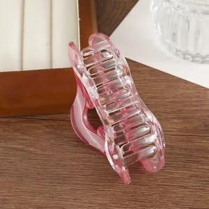 Détail d'une pince à cheveux nuage rose dégradé avec texture transparente sur bois