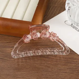 Dettaglio ravvicinato del fermaglio per capelli in resina rosa con fiori e strass