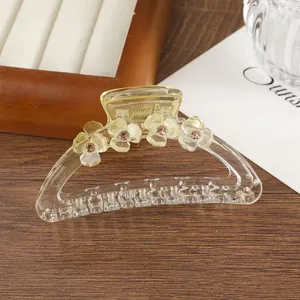 Dettaglio della pinza per capelli a fiori giallo trasparente con strass champagne