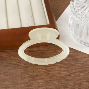 Détail d'une pince à cheveux en résine translucide beige avec motif ovale évidé