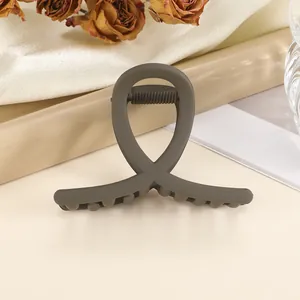 Detail of dark grey matte claw clip with sleek crossed design and strong spring grip