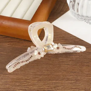 Detail of floral hair claw clip with amber gemstone and rhinestone embellishments