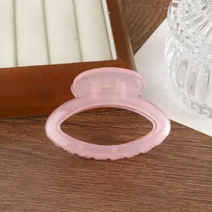 Détail macro d'une pince à cheveux rose translucide avec ressort en métal argenté
