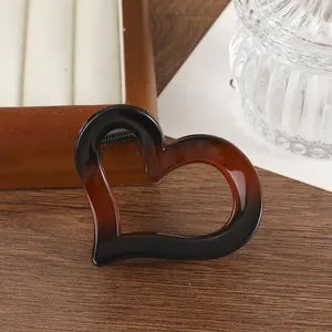 Dettaglio della pinza per capelli a cuore tartarugata su una base in legno