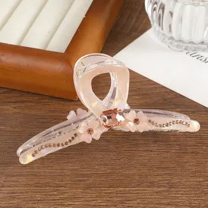 Detail of translucent pink flower hair claw with rhinestones and large crystal center