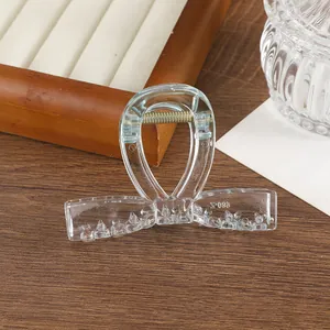 Detalle de pinza de pelo transparente con lazo mostrando dientes antideslizantes y muelle