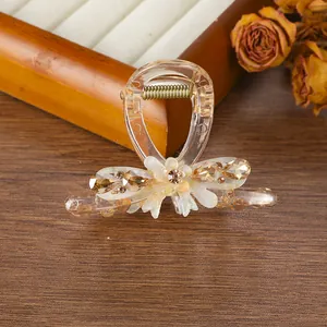 Detalle de pinza para el cabello de resina champán con gema de gota y flores