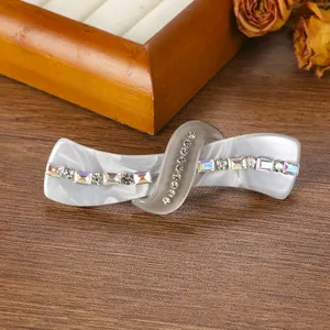 Detail view of marble acetate hair clip with sparkling rhinestones and colorful gemstones