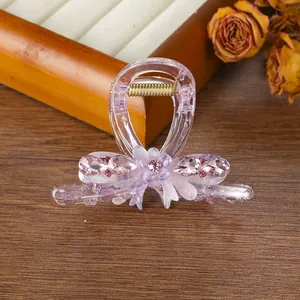 Primer plano de una pinza para el cabello lavanda con lazo, flor y cristales rosas