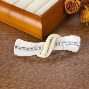 Close-up of vintage marble acetate hair clip with sparkling rhinestones on wood
