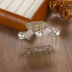 Detail view of champagne hair claw clip with floral rhinestones and opal-style flowers
