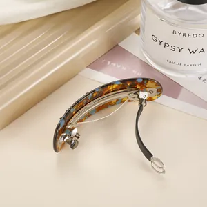 Elegant acetate tortoise shell spring hair clip on a minimalist decorative tray