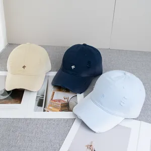 Detail of embroidered cotton baseball caps with vintage distressed texture on magazines