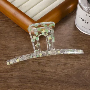 Gros plan d'une pince à cheveux en acrylique à motif floral sur un support en bois