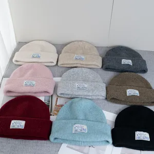 Cozy wool knit beanie for women in nine colors with rib-knit texture and branded patch