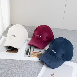 Distressed cotton baseball caps with Smile embroidery in cream, burgundy, and navy blue