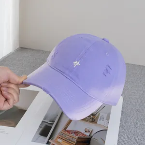 Detailed close-up of light purple distressed baseball cap with white embroidery