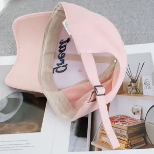Pink cotton baseball cap with embroidered letter details and adjustable metal buckle strap