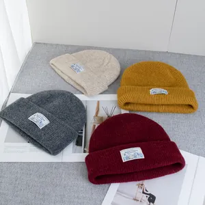 Close-up of ribbed wool knit beanies in beige, mustard, grey and burgundy colors