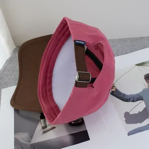 Detalle de gorra de béisbol bicolor de algodón con hebilla ajustable sobre una revista