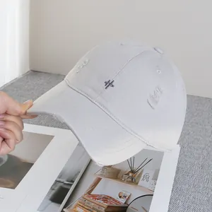 Detail of distressed light gray baseball cap showing frayed edges and embroidery